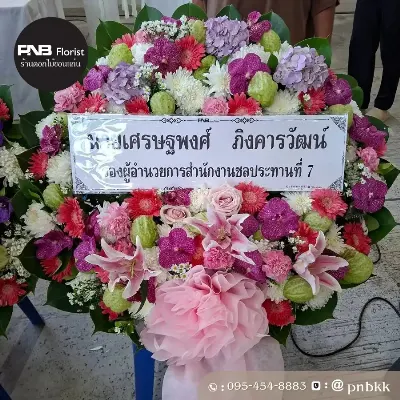 ภาพส่งจริง พวงหรีดดอกไม้สด โทนสีชมพู-ม่วง-ขาว จัดด้วยกล้วยไม้ม่วง ลิลลี่ชมพู ไฮเดรนเยียม่วง เยอบีร่าชมพูแดง และกุหลาบชมพู ประดับโบว์ผ้าชมพู ณ วัดศรีจันทร์ จ.ขอนแก่น ศาลาเตียฮั่วหยู