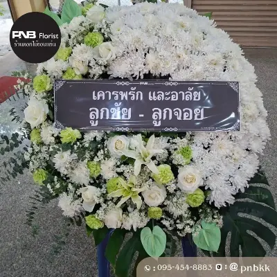 ภาพส่งจริง พวงหรีดดอกไม้สด โทนสีขาว-เขียว จัดด้วยเบญจมาศขาว กุหลาบขาว ลิลลี่ขาว และคาร์เนชั่นเขียว ประดับใบมอนสเตอร่าและยูคาลิปตัส ณ วัดป่าชัยวัน ต.ในเมือง อ.เมือง จ.ขอนแก่น ศาลา 2 บำเพ็ญกุศลประเสริฐรุ่งเรือง