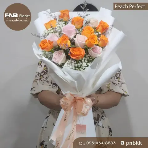 ช่อกุหลาบผสมสีส้มและชมพู โทนสีพีช ห่อขาว ผูกโบว์ครีม ร้านดอกไม้ขอนแก่น ส่งฟรี